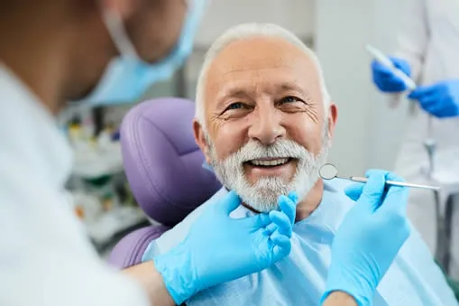 Mature man at dentist's office chair during oral cancer screening